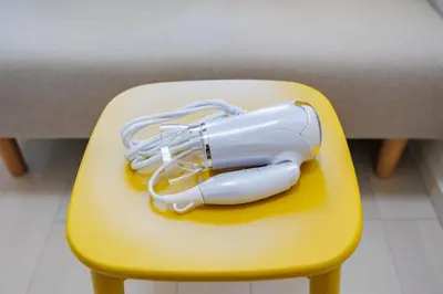 a blow dryer sitting on a yellow chair at Cruise Inn Kitasenju Station Front1 in Tokyo