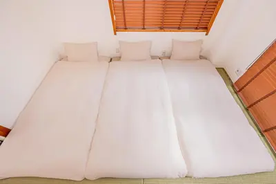 a large white bed in a room with a window at 120sqm 5LDK 3-Stories House 3BT JR Shin-Okubo 5min in Tokyo