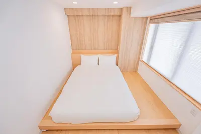 a bed in a small room with a window at 120sqm 5LDK 3-Stories House 3BT JR Shin-Okubo 5min in Tokyo