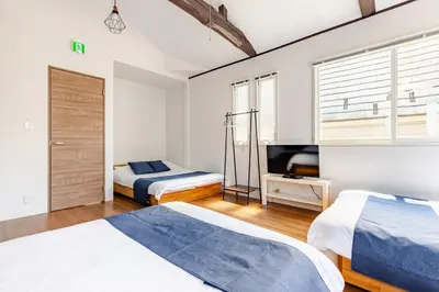 a bedroom with two beds and a television in it at Rtt\u5357\u5143\u753a12 in Tokyo