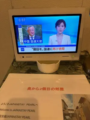 a television with aoreanoreanoreanoreanorean program on the screen at \u5730\u4e0b\u9244\u99c5\u5f92\u6b695\u5206 \u30c7\u30a3\u30ba\u30cb\u30fcDisney\u30d0\u30b9 \u7fbd\u7530\u7a7a\u6e2f \u30ea\u30e0\u30b8\u30f3\u30d0\u30b9 \u7bc9\u6d45 \u6c34\u5727\u826f JAPAN STAY Pearl in Tokyo