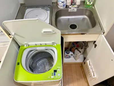 a small kitchen with a washing machine and a sink at Gracious Higashishinjuku - Vacation STAY 35567v in Tokyo