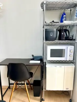 a kitchen with a desk with a microwave and a shelf at Gracious Higashishinjuku - Vacation STAY 35567v in Tokyo