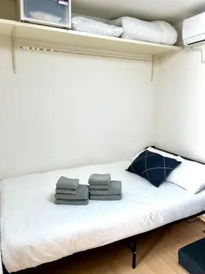 a bed in a room with towels on a shelf at Gracious Higashishinjuku - Vacation STAY 35567v in Tokyo