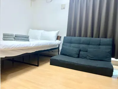 a bed and a couch in a room at Gracious Higashishinjuku - Vacation STAY 35525v in Tokyo