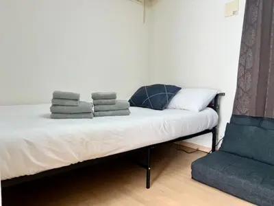 a bed with towels on top of it with a chair at Gracious Higashishinjuku - Vacation STAY 35525v in Tokyo