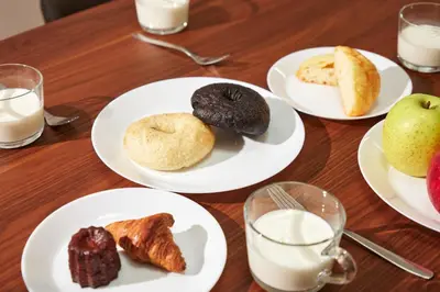 a table with plates of pastries and glasses of milk at \u3068\u307e\u308a\u30fc\u3068Stay \u5e61\u30f6\u8c37 \u6e0b\u8c37\u533a Tomareat Stay Hatagaya Shibuya City in Tokyo