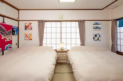 two twin beds in a room with a window at \u3068\u307e\u308a\u30fc\u3068Stay \u5e61\u30f6\u8c37 \u6e0b\u8c37\u533a Tomareat Stay Hatagaya Shibuya City in Tokyo
