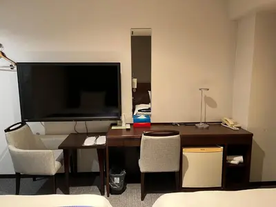 a room with a desk with a television and chairs at KKR Hotel Nakameguro in Tokyo