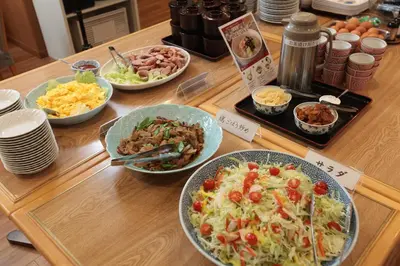 a wooden table with plates of food on it at KKR Hotel Nakameguro in Tokyo