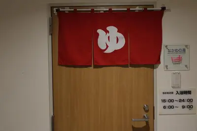 a door with a red curtain with a sign on it at KKR Hotel Nakameguro in Tokyo