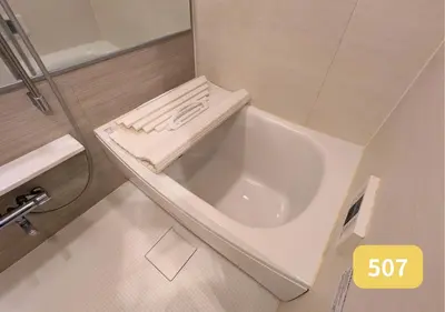 a white bath tub in a small bathroom at Westside Shinjuku-Gyoen 507 in Tokyo
