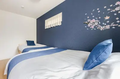 a bedroom with two beds and a wall with flowers at Jtr\u5927\u548c\u753a1\u4e01\u76ee\u6238\u5efa in Tokyo