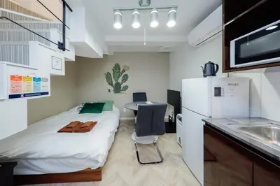 a small room with a bed and a table and a refrigerator at monthly Ra Grande in Tokyo