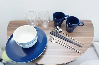 a wooden table with blue plates and cups and utensils at monthly Ra Grande in Tokyo