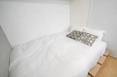 a white bed with two pillows on top of it at monthly prime shinjuku in Tokyo