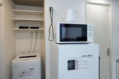 a microwave sitting on top of a refrigerator at monthly RECO WASEDA in Tokyo