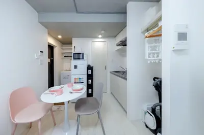a small white kitchen with a white table and chairs at monthly RECO WASEDA in Tokyo