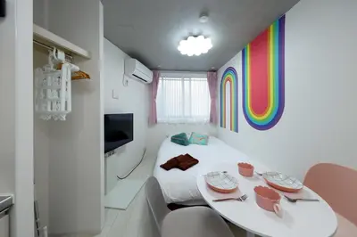 a room with a table with a rainbow on the wall at monthly RECO WASEDA in Tokyo