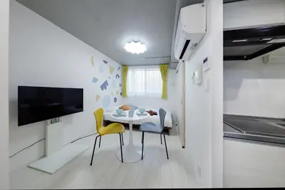 a small dining room with a table and yellow chairs at monthly RECO WASEDA in Tokyo