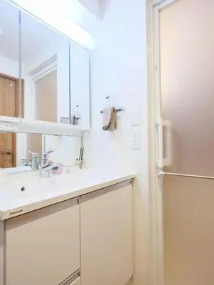 a white bathroom with a sink and a refrigerator at LANG Hotel Kitaueno in Tokyo