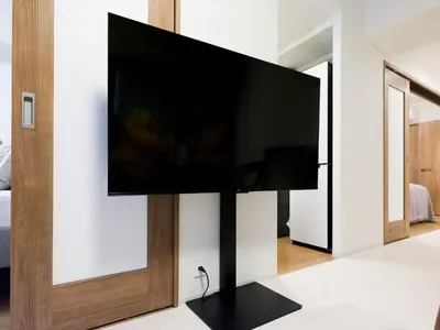 a flat screen tv on a stand in a living room at LANG Hotel Kitaueno in Tokyo