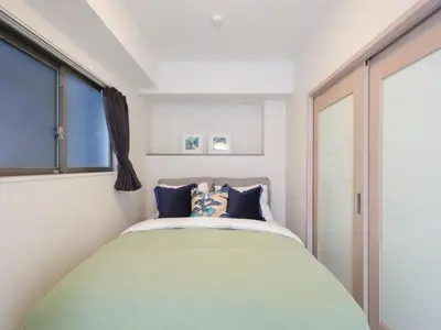 a bedroom with a large bed with blue pillows at LANG Hotel Kitaueno in Tokyo