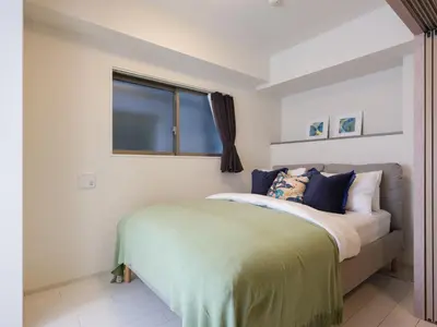 a bedroom with a bed and a window at LANG Hotel Kitaueno in Tokyo