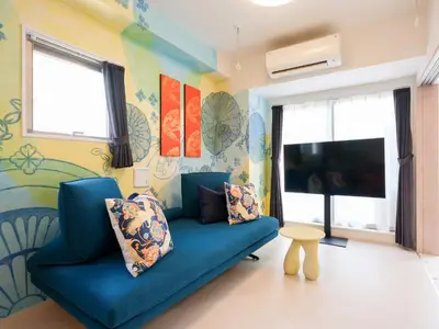 a living room with a blue couch and a tv at LANG Hotel Kitaueno in Tokyo