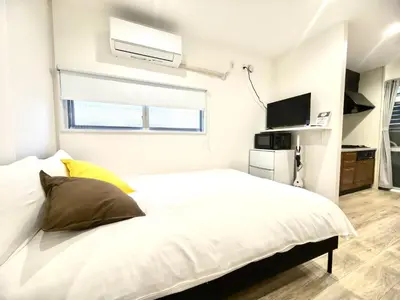 a white bedroom with a bed and a tv at Nippori mansion#Arakawa-ku in Tokyo