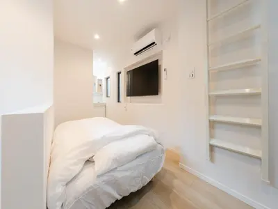 a white bedroom with a bed and a tv at Shibuya Sta 10min walk Kingbed VR Switch Wi-Fi in Tokyo