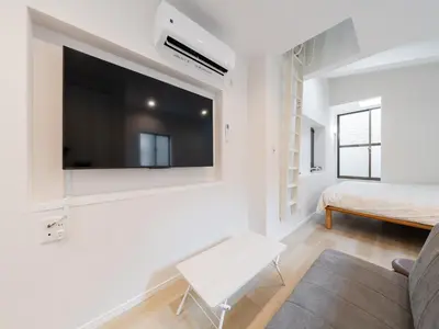 a living room with a flat screen tv on a wall at Shibuya Sta 10min walk Kingbed VR Switch Wi-Fi in Tokyo