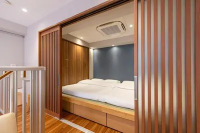 a bedroom with a bed in a room with a mirror at GInza6-7F in Tokyo