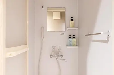 a white bathroom with a shower and a sink at GInza6-7F in Tokyo