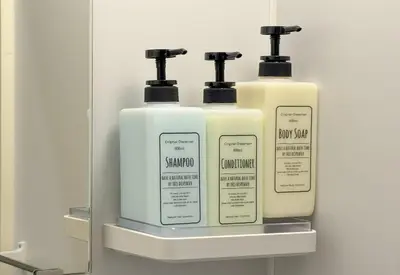 three bottles of shampoo and soap on a shelf in a bathroom at GInza6-7F in Tokyo