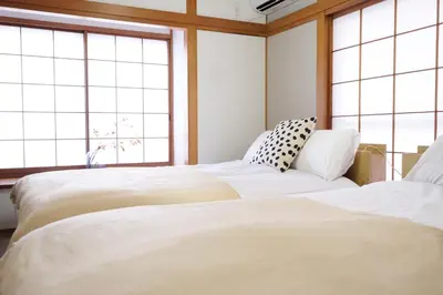 two beds in a room with large windows at Yoyogi New Flats - Vacation STAY 20252 in Tokyo