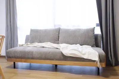 a couch with a blanket on it in front of a window at Yoyogi New Flats - Vacation STAY 20252 in Tokyo