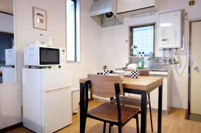 a small kitchen with a table and a refrigerator at Yoyogi New Flats - Vacation STAY 20254 in Tokyo