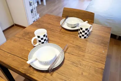 a wooden table with plates and mugs on it at Yoyogi New Flats - Vacation STAY 20254 in Tokyo
