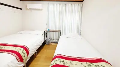 two twin beds in a room with a window at Espoir - Vacation STAY 42528v in Tokyo