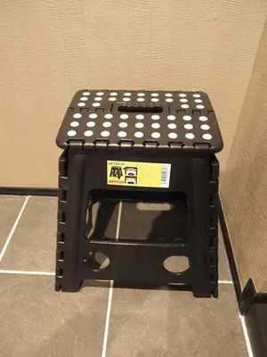 a black stool sitting on the floor in a room at T-home\u6953 T-home Fu in Tokyo