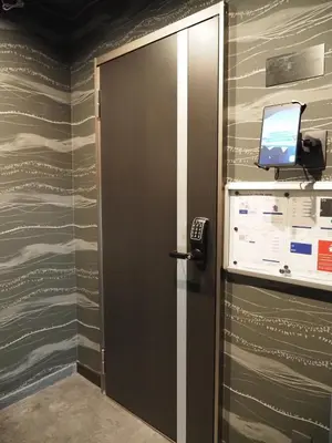 a door in a room with a television on a wall at T-home\u6953 T-home Fu in Tokyo
