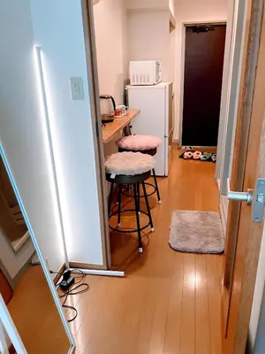 a kitchen with a table and a refrigerator and a stool at Cozy Stay Ebisu in Tokyo