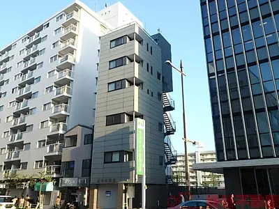 a tall building in front of two tall buildings at Cozy Stay Ebisu in Tokyo