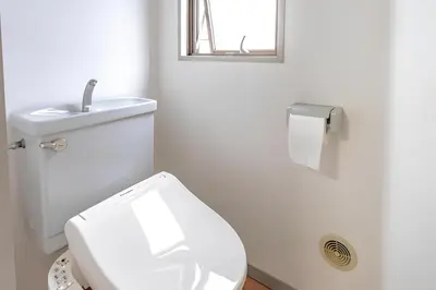 a white bathroom with a toilet and a sink at Cozy Stay Ebisu in Tokyo