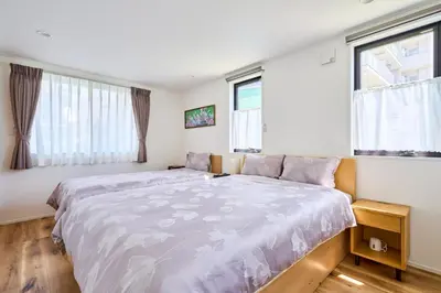 a bedroom with a large bed and two windows at EK Stay Tenku-no-ki \u5929\u7a7a\u306e\u6a39 Asakusa SkyTree Area 4BR Chic House Near Station in Tokyo