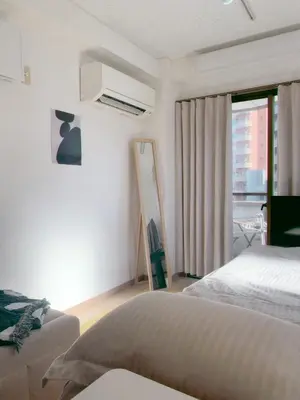 a white bedroom with a bed and a window at Homestay in hiroo in Tokyo
