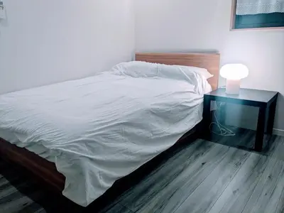 a bedroom with a bed with a night stand and a lamp at Homestay in hiroo in Tokyo