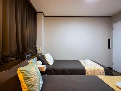 a hotel room with two beds and curtains at Mando Hotel \u6b65\u884c\u81f3 Asakusa Ueno in Tokyo
