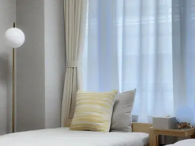 a bed with a yellow and white pillow next to a window at Mando Hotel \u6b65\u884c\u81f3 Asakusa Ueno in Tokyo